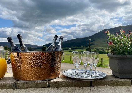 Champagne on ice at Glen Clova Hotel with the rolling hills in the background