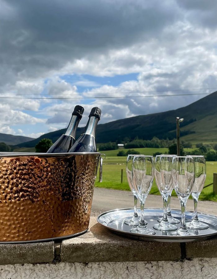 Champagne on ice at Glen Clova Hotel with the rolling hills in the background