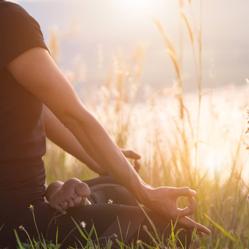 Woman meditating outdoors by the water