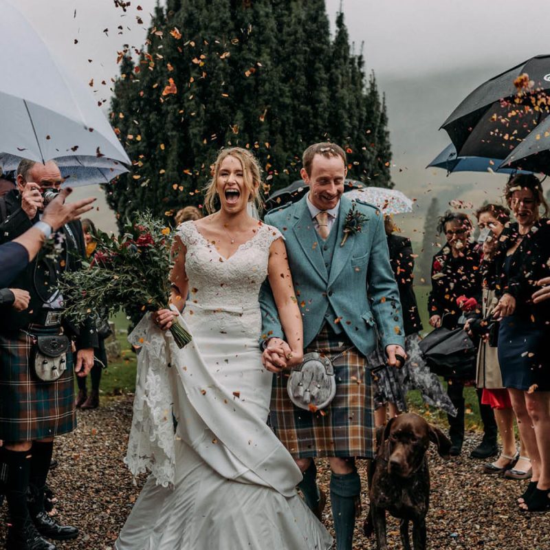 A Bride and Groom and their Dog with confetti being thrown over them. Photography by Burfly. https://burfly.co.uk/