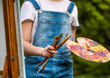 Woman at easel with paint and brushes