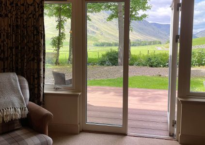 A view out of the patio doors in the living room of Brandy Lodge over Glen Clova at Glen Clova Hotel and Lodges in Scotland