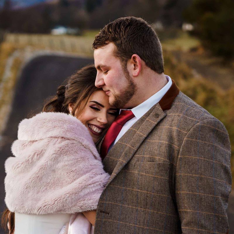 A bride and groom cuddling at their wedding in Glen Clova. Photography by Barry Robb Photography. https://barryrobbphotography.com/