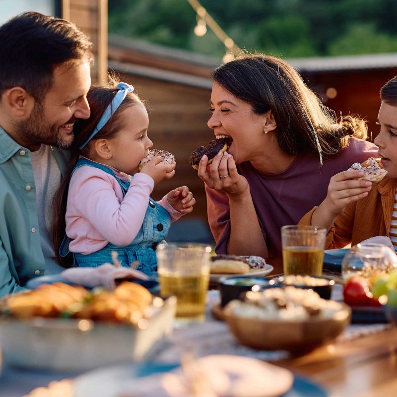 A family having fun and enjoying food outside at their holiday lodge