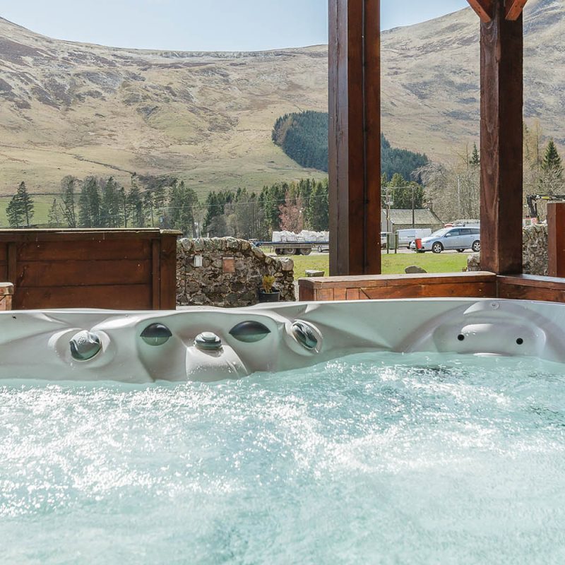 A hot tub with a stunning view on a Glen Lodge at Glen Clova Hotel and Lodges in Scotland