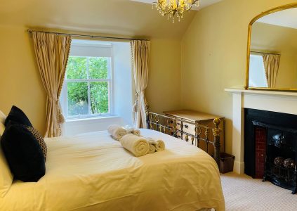 The elegant double bedroom with an old fireplace in The Old Manse at Glen Clova Hotel and Lodges in Scotland