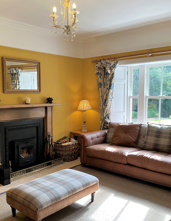 The cosy living room with a log burner in The Old Manse at Glen Clova Hotel and Lodges in Scotland