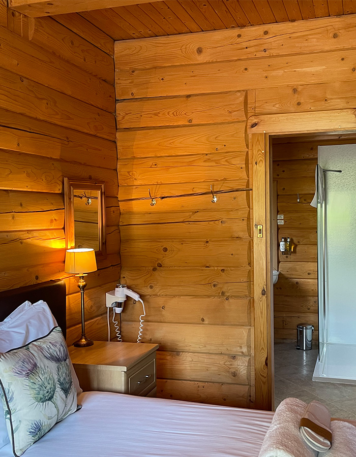 A bedroom with an ensuite in a Glen Lodge at Glen Clova Hotel