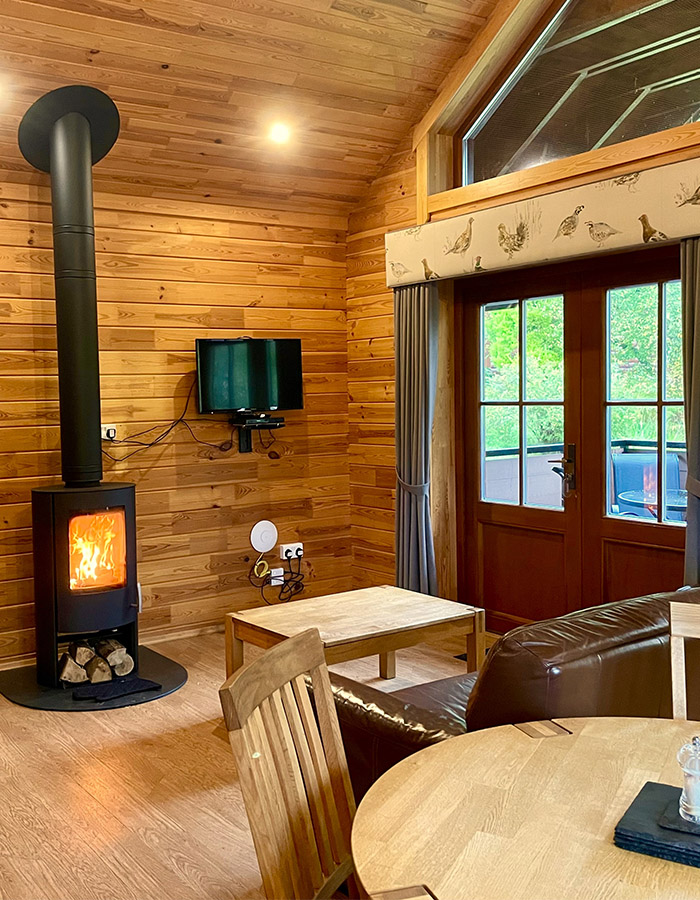 The living room with stove in a Hideaway Lodge at Glen Clova Hotel