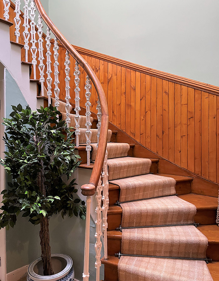 A sweeping staircase in The Old Manse at Glen Clova Hotel