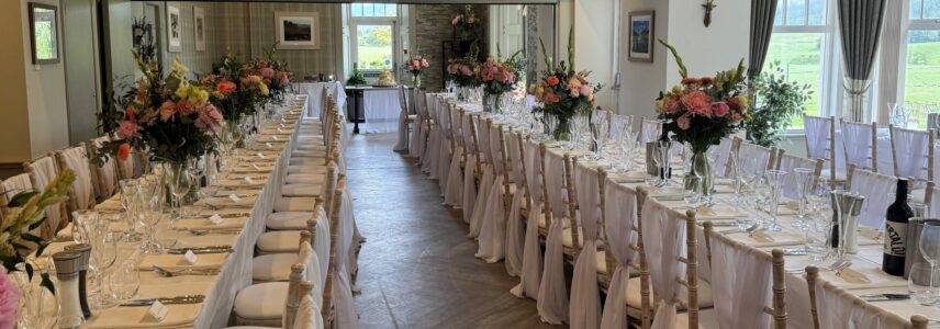 Flowers on long tables set for wedding