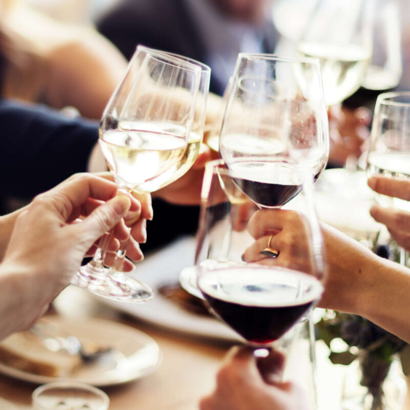 Diners clinking wine glasses at a business meal