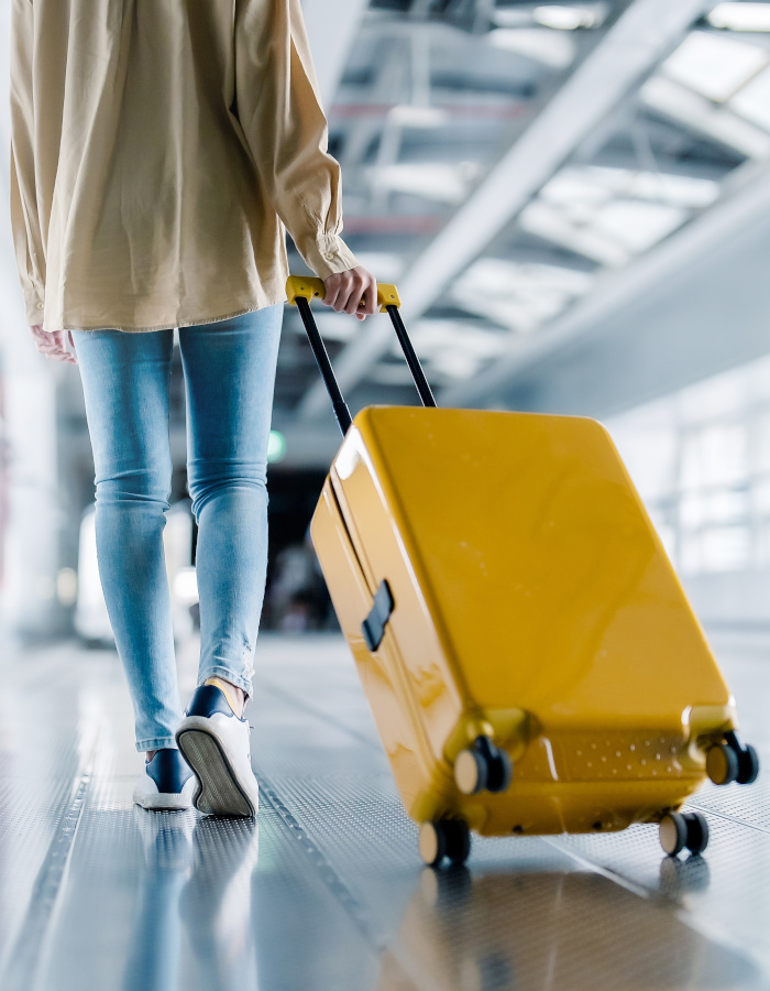 Woman with a yellow suitcase at the airport