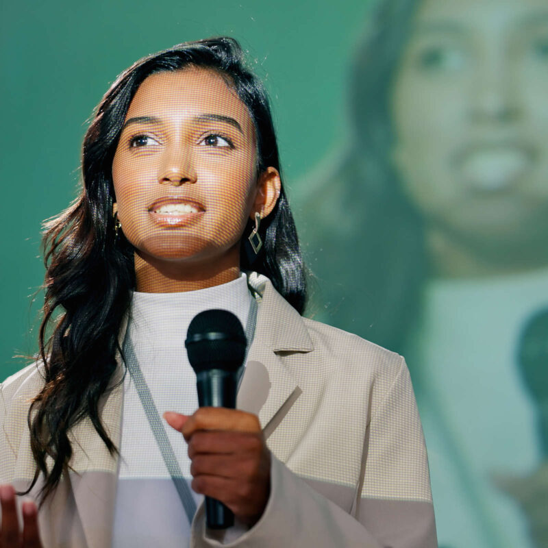 Woman with microphone on stage for conference speech