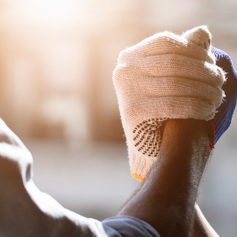 Two construction workers clasping hands together